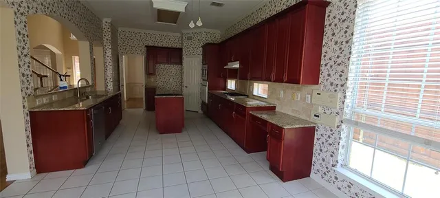 a kitchen with stainless steel appliances granite countertop a stove a sink and a microwave