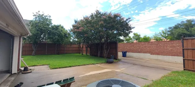a view of a backyard with wooden fence