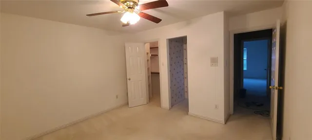 an empty room with closet and a chandelier fan