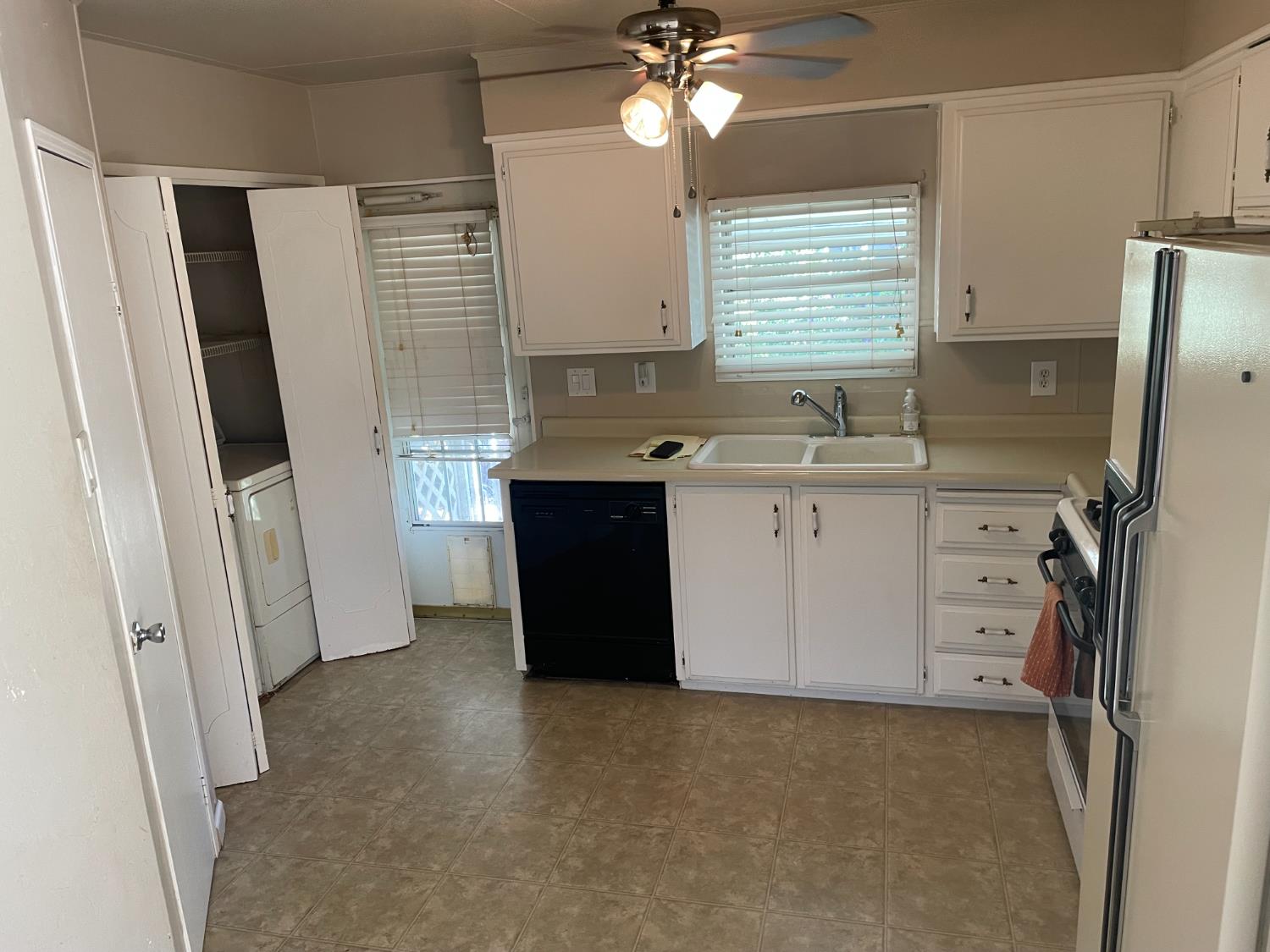 5835 Cherokee Road, Unit 61 Stockton, CA 95215 - Photo 2 of 10 a kitchen with a sink a refrigerator a window and cabinets