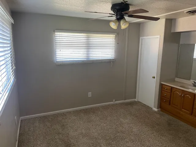 a view of an empty room with window and cabinet