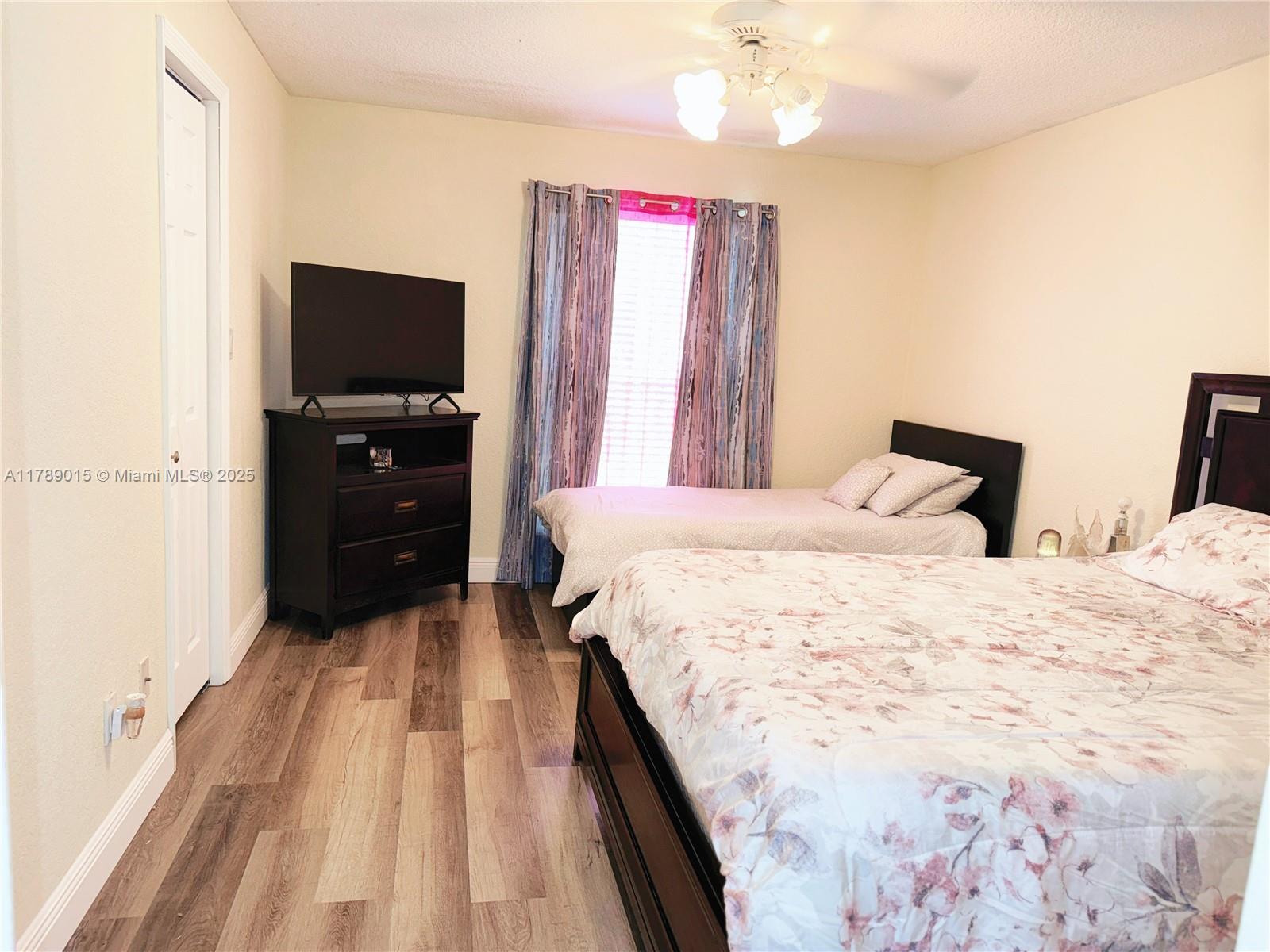 805 Riverside Drive, Unit 1111 Coral Springs, FL 33071 - Photo 11 of 16 a bedroom with a bed and a flat screen tv