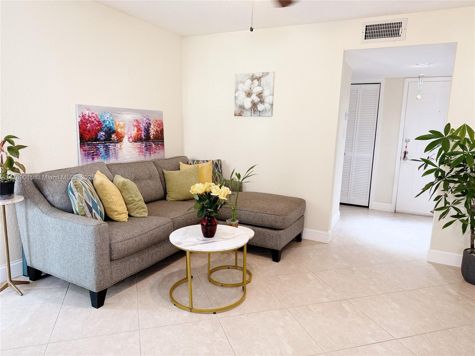 805 Riverside Drive, Unit 1111 Coral Springs, FL 33071 - Photo 5 of 16 a living room with furniture and a potted plant