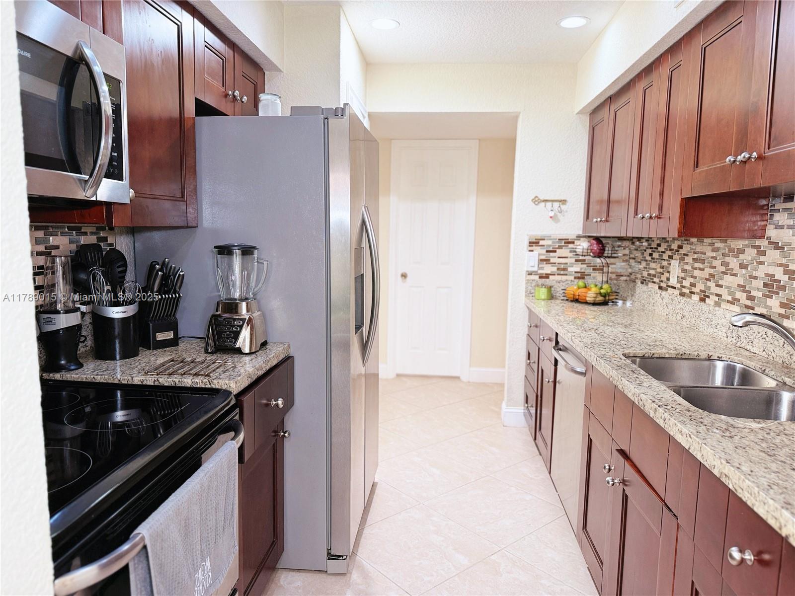 805 Riverside Drive, Unit 1111 Coral Springs, FL 33071 - Photo 7 of 16 a kitchen with stainless steel appliances granite countertop a sink stove and refrigerator