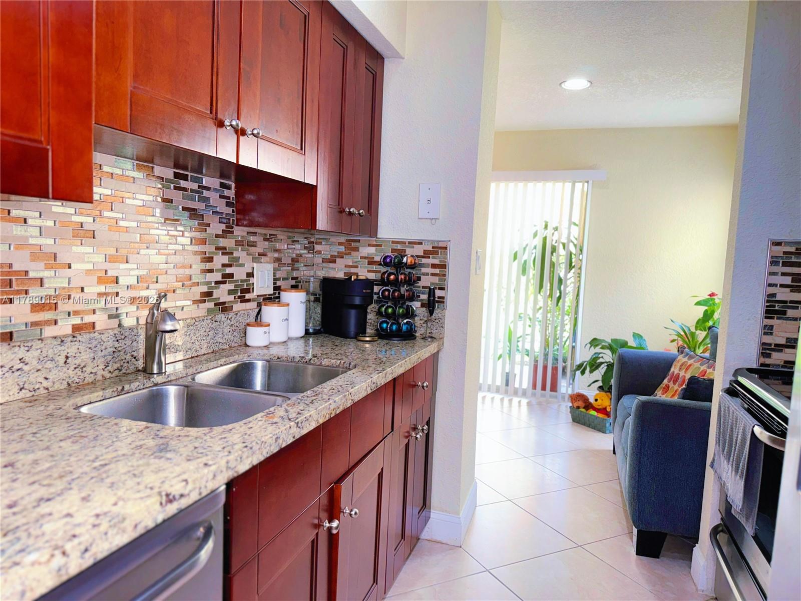 805 Riverside Drive, Unit 1111 Coral Springs, FL 33071 - Photo 8 of 16 a kitchen with stainless steel appliances granite countertop a sink a stove and a wooden cabinets