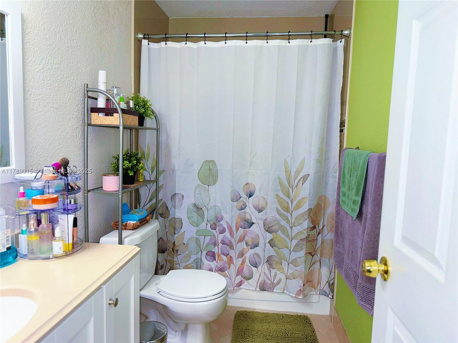 805 Riverside Drive, Unit 1111 Coral Springs, FL 33071 - Photo 10 of 16 a bathroom with a sink a toilet and shower curtain