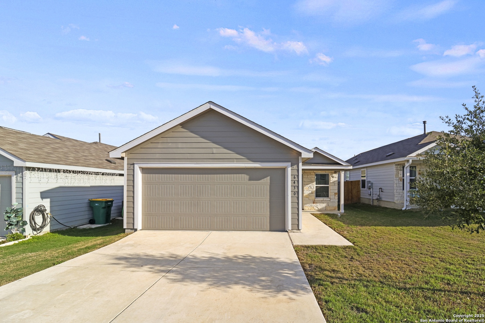 a front view of house with yard and trees in the background