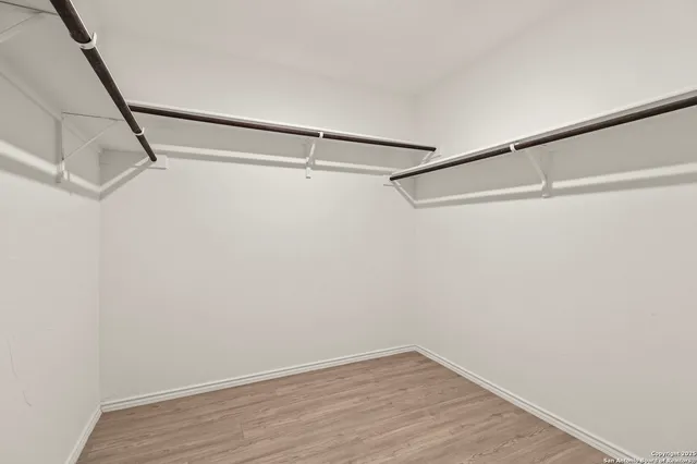 a view of a room with wooden floor and small window