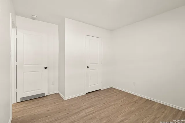 a view of an empty room with wooden floor