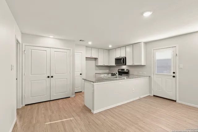 a kitchen with stainless steel appliances a white stove top oven cabinets and a refrigerator