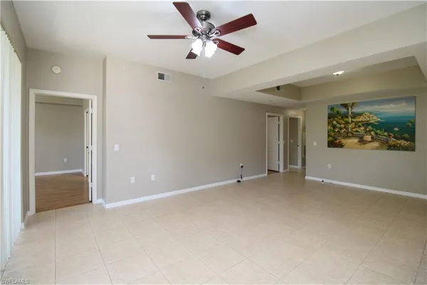 an empty room with window and a ceiling fan