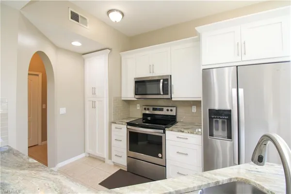 a kitchen with stainless steel appliances a refrigerator sink and microwave
