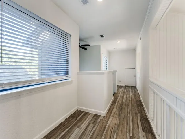 a view of a room with wooden floor and a window