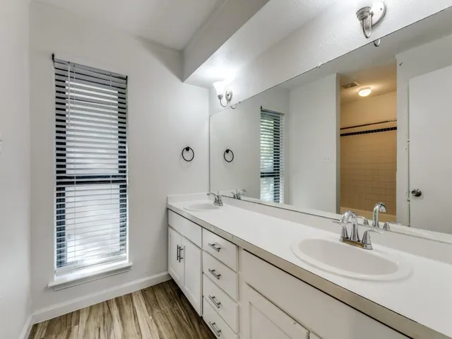 a bathroom with a double vanity sink and a mirror