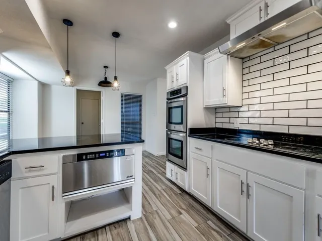 a kitchen with stainless steel appliances white cabinets and a sink