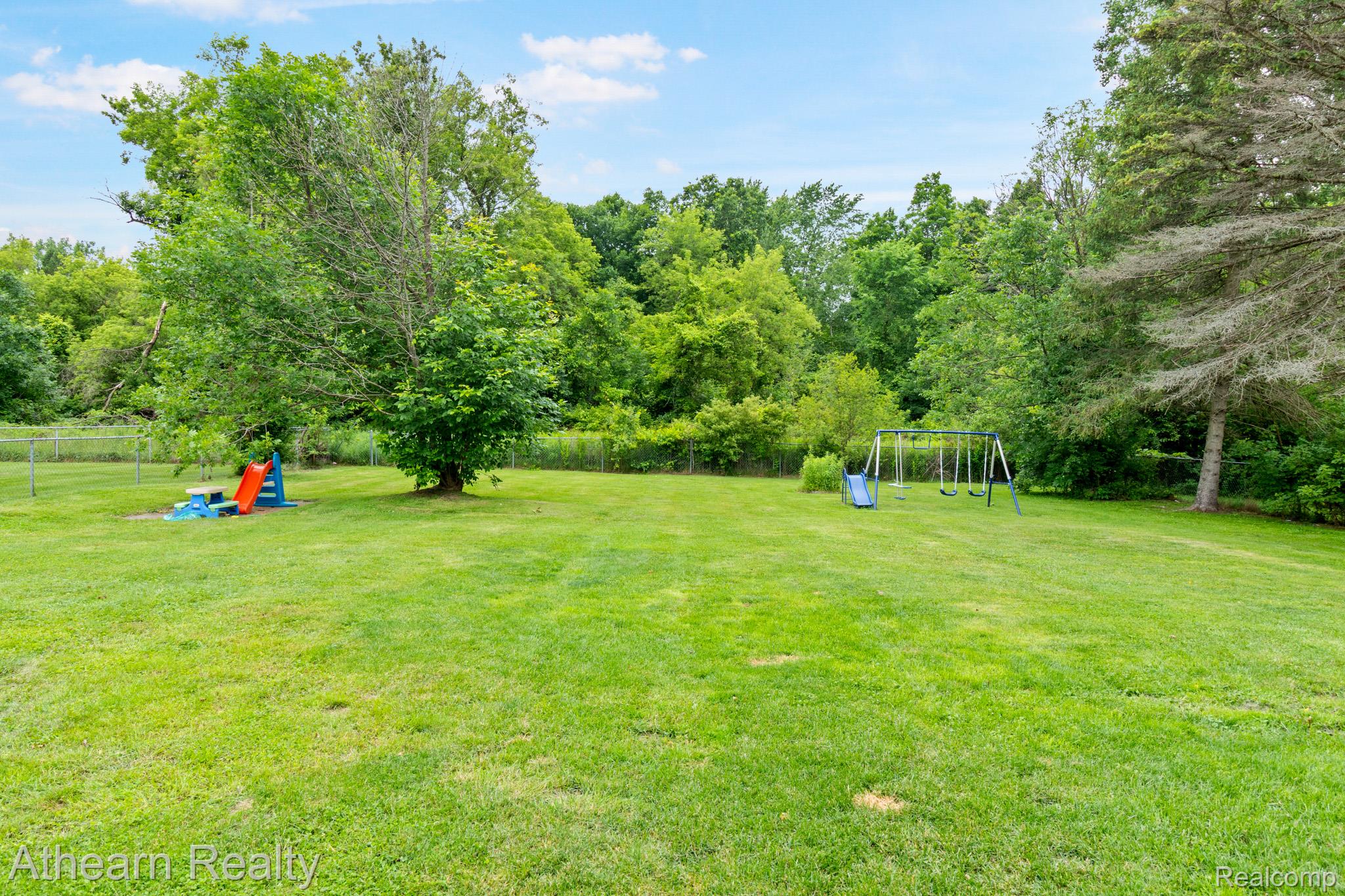 7156 Sharp Road Swartz Creek, MI 48473 - Photo 5 of 32 Expansive lawn featuring mature trees and a fenced perimeter