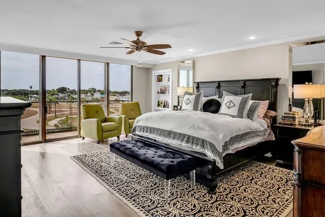 a bedroom with a bed a couch and a large window