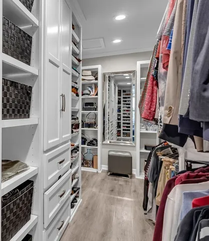 a view of walk in closet with clothes and shoes