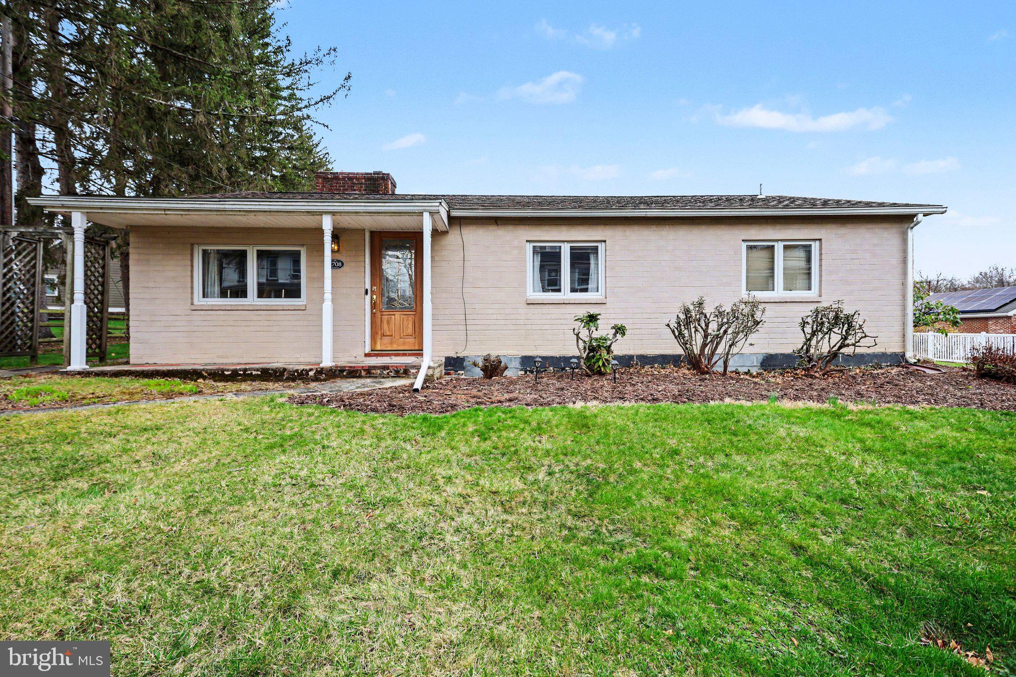 Charming brick home with lush greenery.