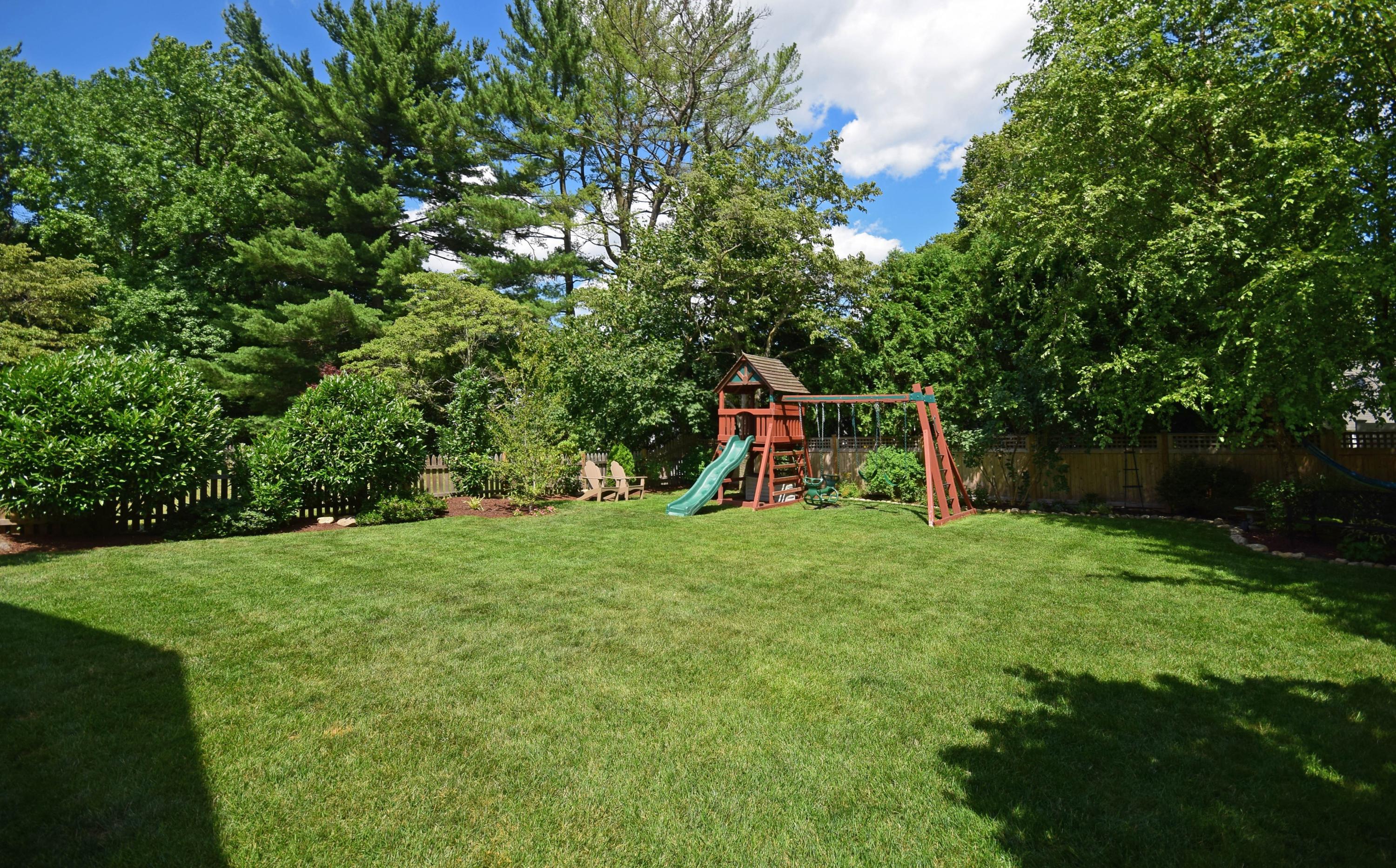 35 Ridgeley Street Darien, CT 06820 - Photo 22 of 25 a view of a backyard with a slide trees and wooden fence