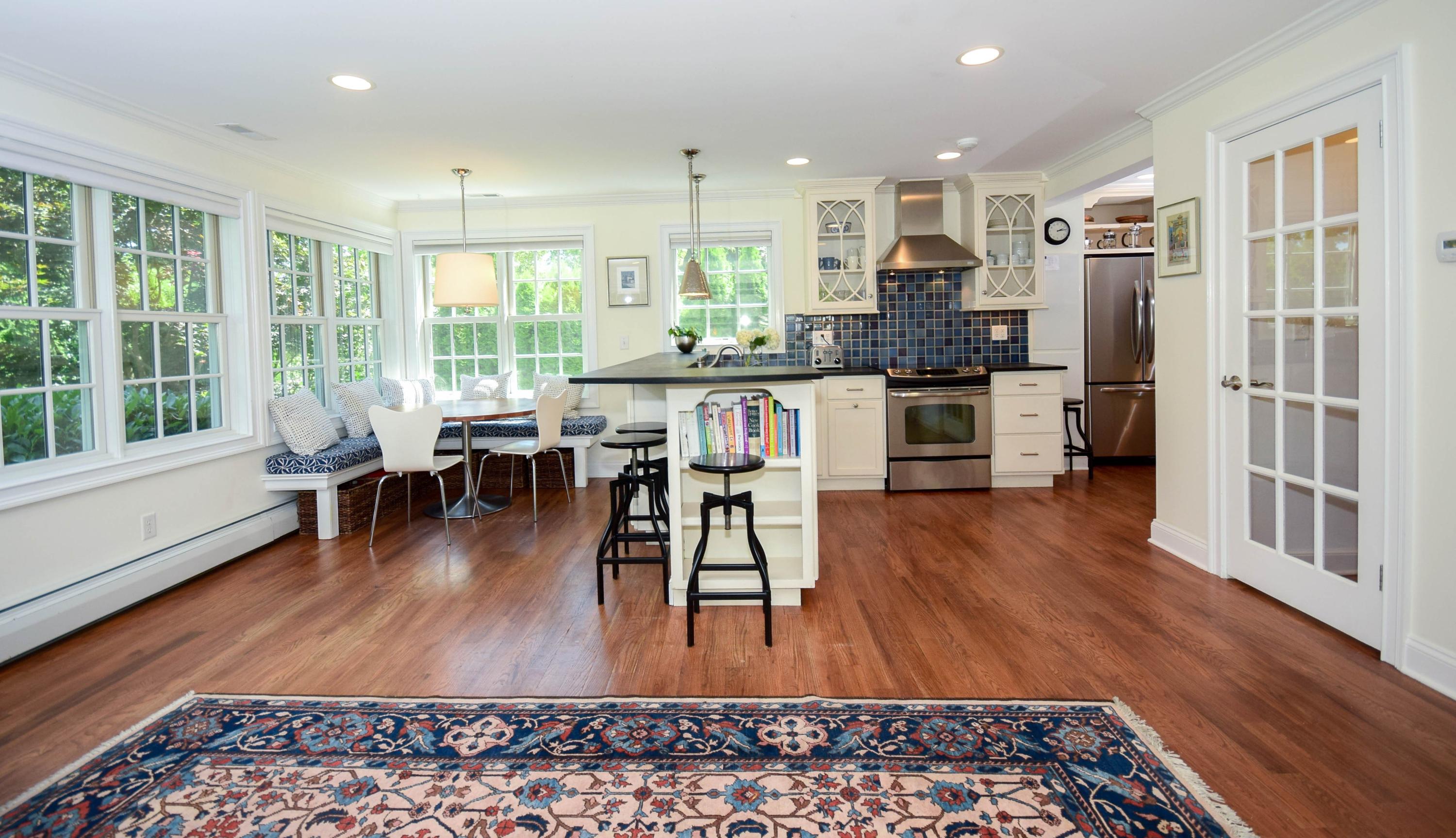 35 Ridgeley Street Darien, CT 06820 - Photo 6 of 25 a kitchen with stainless steel appliances granite countertop a stove a refrigerator a sink a dining table and chairs with wooden floor