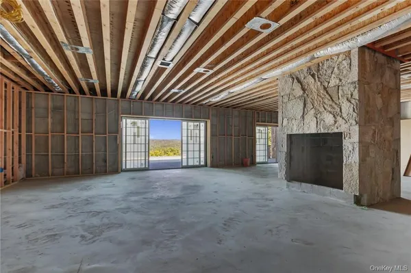 a view of an empty room with a fireplace and a window