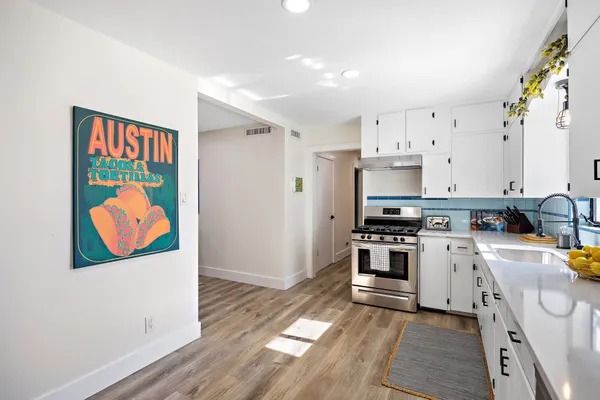 a kitchen with stainless steel appliances a stove a sink and a refrigerator