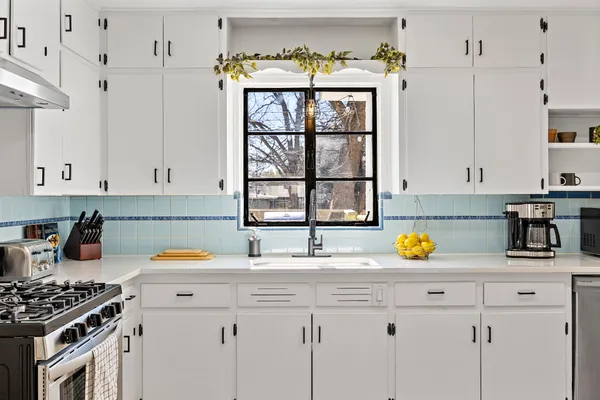 a kitchen with a sink a stove and cabinets
