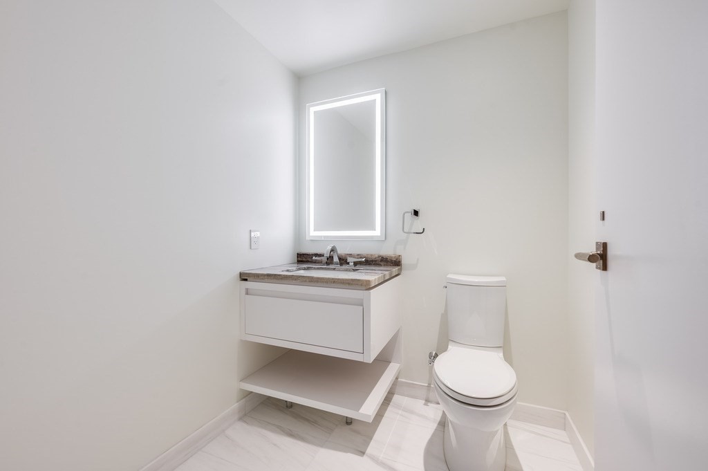 150 Seaport Boulevard, Unit 17D Boston, MA 02210 - Photo 14 of 24 a bathroom with a sink toilet and mirror