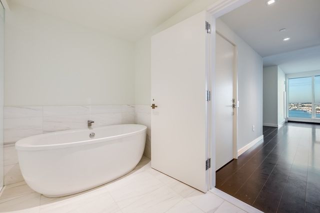 a spacious bedroom with a bed and a flat screen tv