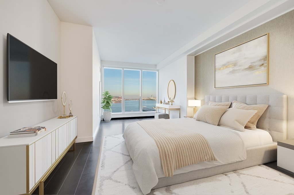 150 Seaport Boulevard, Unit 17D Boston, MA 02210 - Photo 10 of 24 a spacious bedroom with a bed and a flat screen tv
