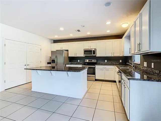 a living room with furniture a flat screen tv and a table