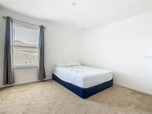a large bed in a white room