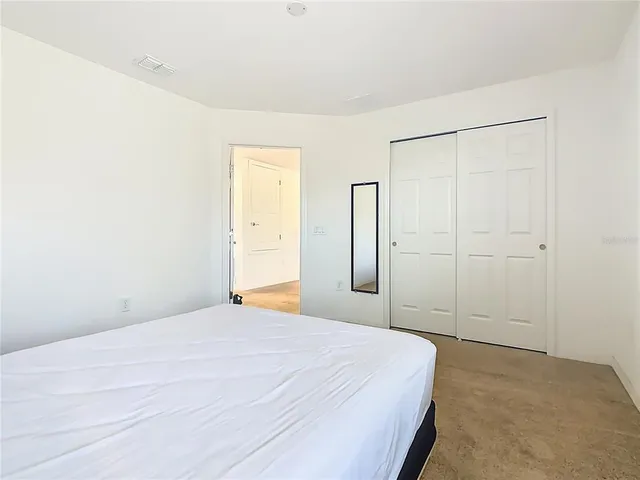 a bed sitting in a bedroom next to a window