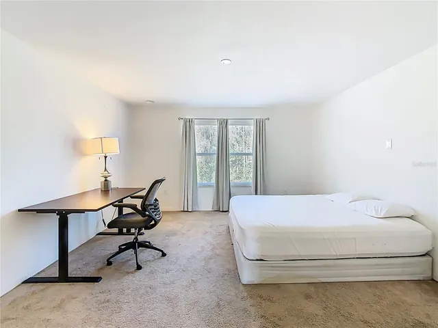 a bedroom with a bed and a painting on the wall