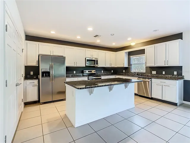 a kitchen with stainless steel appliances granite countertop a sink and cabinets