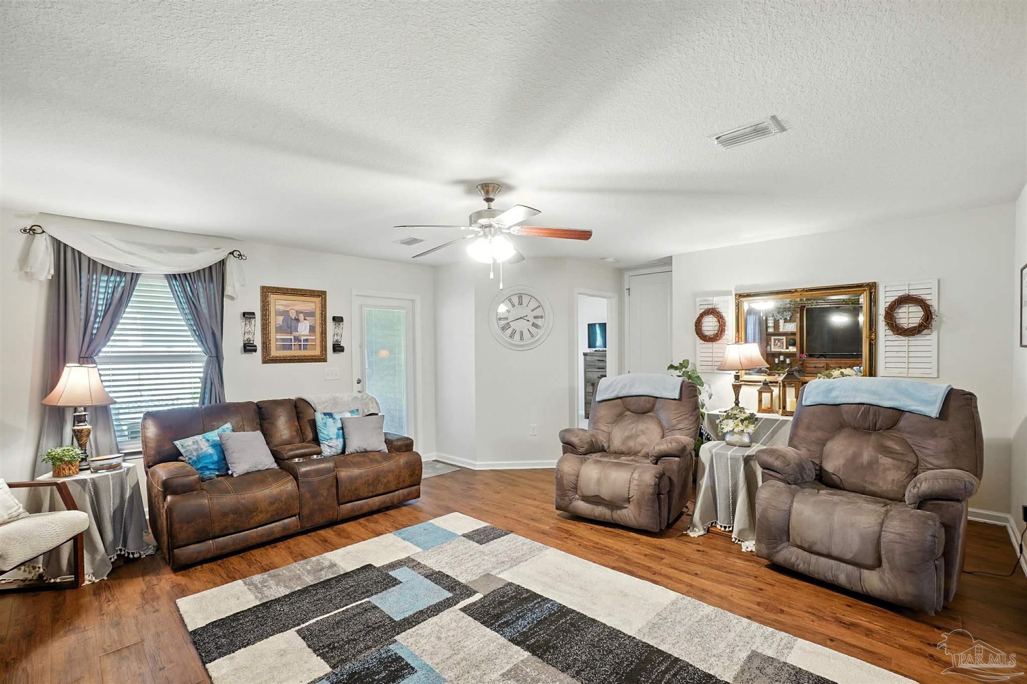 4734 Apple Field Way Pace, FL 32571 - Photo 14 of 31 a living room with furniture and a chandelier