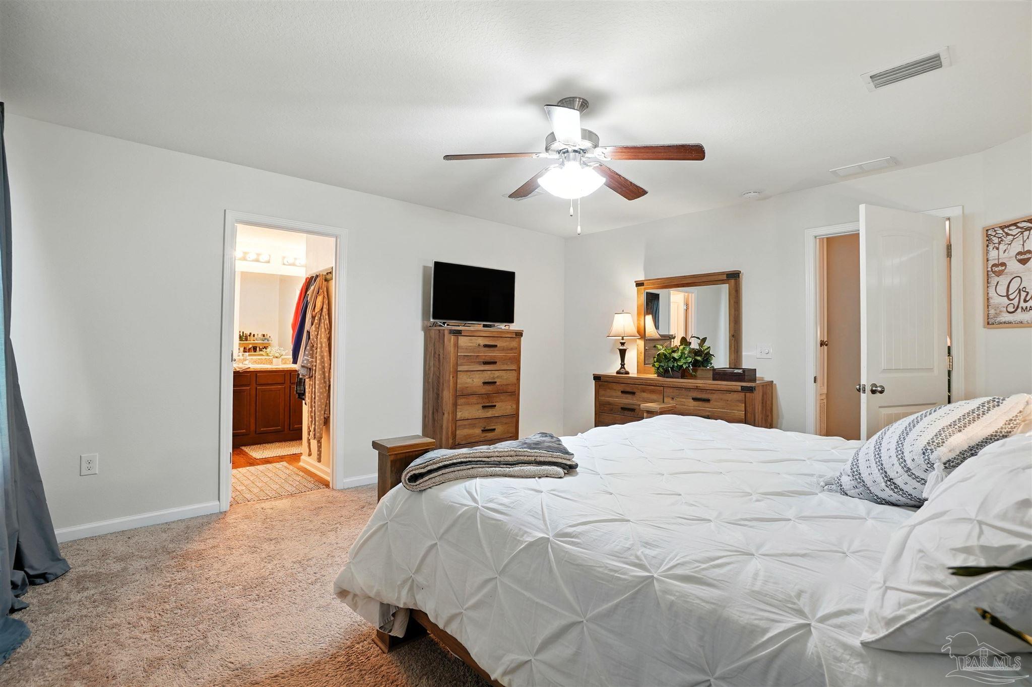 4734 Apple Field Way Pace, FL 32571 - Photo 19 of 31 a bedroom with a bed and a chandelier