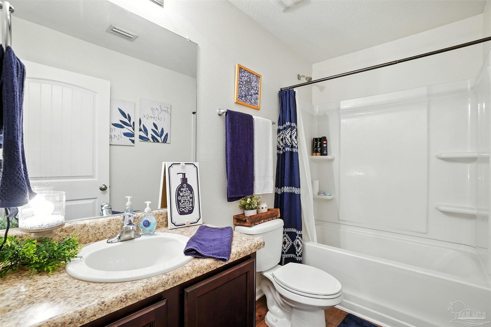 4734 Apple Field Way Pace, FL 32571 - Photo 23 of 31 a bathroom with a granite countertop sink toilet and shower