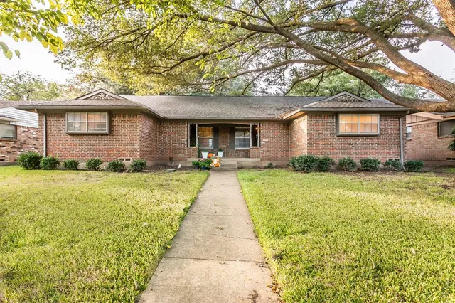a front view of a house with a yard and trees