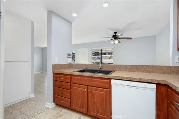 a kitchen with a granite countertop sink and white cabinets