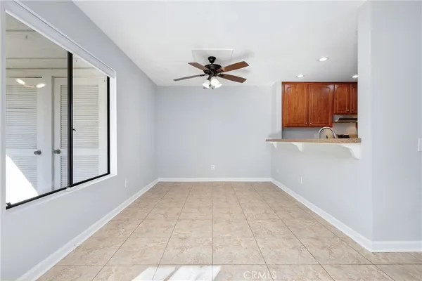 an empty room with a ceiling fan and a window