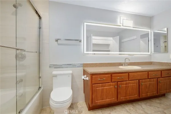 a spacious bathroom with a granite countertop toilet sink and a mirror