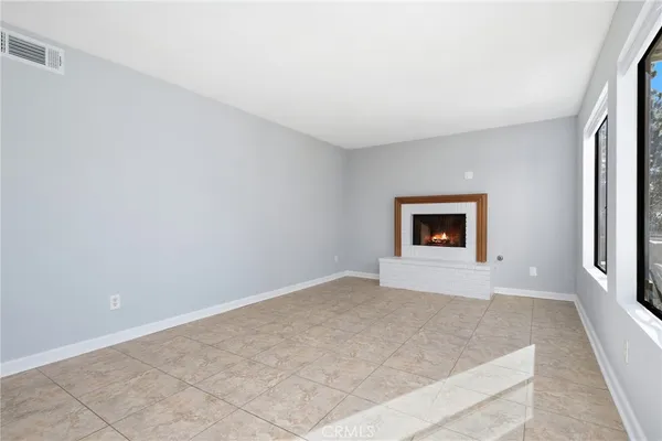 an empty room with windows and a ceiling fan