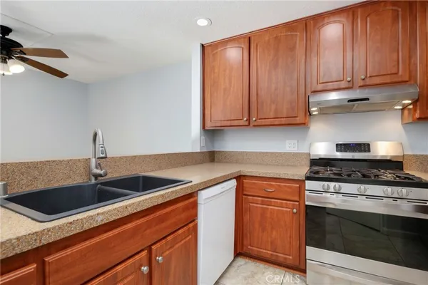 a kitchen with granite countertop a sink stainless steel appliances and cabinets