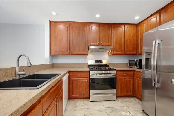 a kitchen with stainless steel appliances granite countertop a stove sink and refrigerator