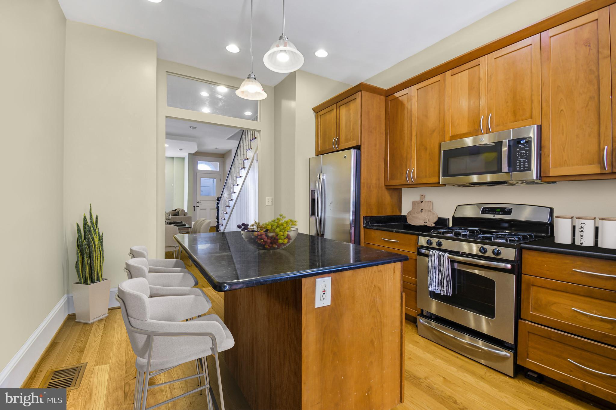 1330 35th Street Northwest Washington, DC 20007 - Photo 10 of 30 a kitchen with stainless steel appliances kitchen island granite countertop a stove refrigerator and microwave