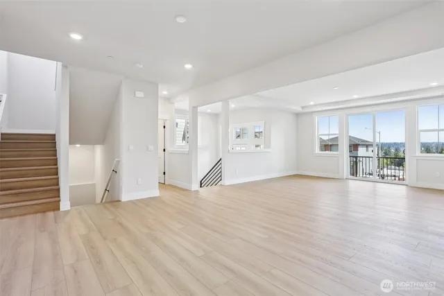 a view of empty room with wooden floor and floor to ceiling window