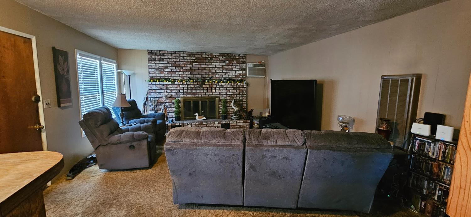 20822 Disch Road Lockeford, CA 95237 - Photo 5 of 30 a living room with furniture a flat screen tv and a large window