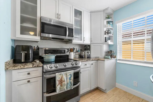 a kitchen with stainless steel appliances granite countertop a stove a sink and a microwave